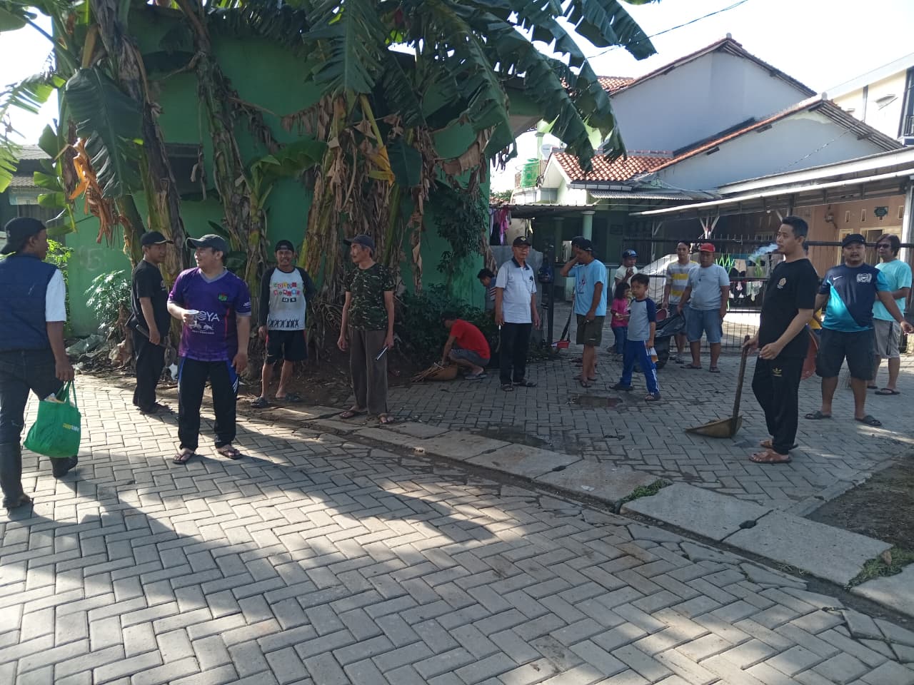 Sejumlah warga RT 05/04 Kelurahan Kenanga, Kecamatan Cipondoh, Kota Tangerang, tengah bersiap melakukan kegiatan gotong royong membersihkan lingkungan. Beberapa warga terlihat membawa alat kebersihan seperti sapu dan cangkul, menunjukkan semangat kebersamaan di tengah suasana pagi hari.