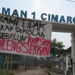 Spanduk protes siswa terpampang di gerbang SMAN 1 Cimarga, Lebak, Senin (13/10/2025).