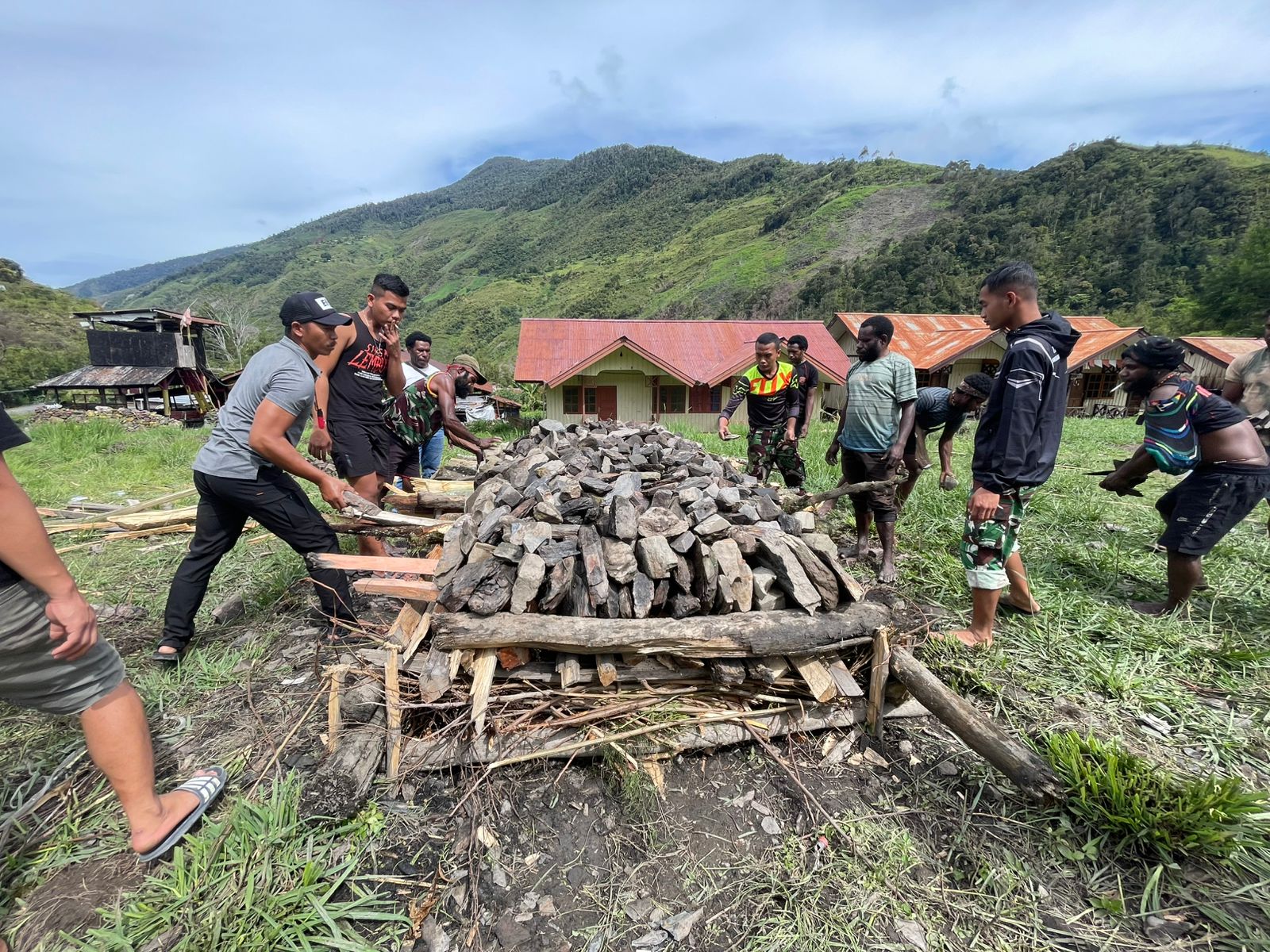 Warga  bersama-sama menyiapkan tumpukan batu untuk pelaksanaan tradisi Bakar Batu di Distrik Tingginambut, Papua Tengah. Dok. Istimewa/Baratv.id – Aldino.