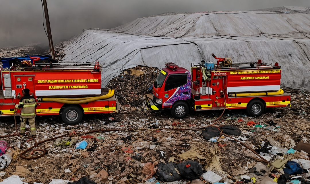 Petugas pemadam kebakaran berupaya memadamkan api saat asap mengepul dari sampah yang terbakar di lokasi TPA Jatiwaringin di Tangerang, Provinsi Banten, Indonesia, 2 Juli 2026. Foto: Aris/Red Baratv.id